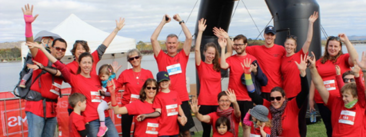 MS Walk run and roll participants at finishing line. A group of happy people.