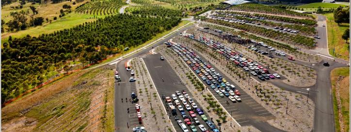 A colourful convoy of vehicles parked in a large carpark 