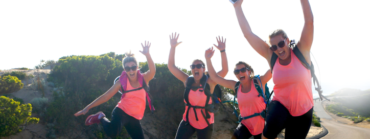 Women jumping for joy in matching pink shirts