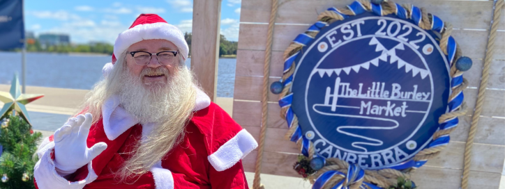 Santa posing with the Little Burley Market Sign