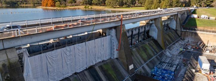 This image is an aerial shot of Scrivener Dam showing the encapsulation within the sluice and flood gates with a view to Telstra Tower.