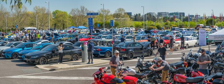 Cars parked in a large parking lot at an official event