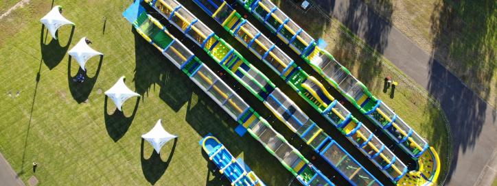 A large and colourful inflatable course on grass