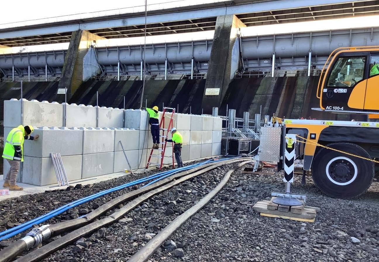 This image shows workers installing the concrete 'lego blocks' of the temporary cofferdam