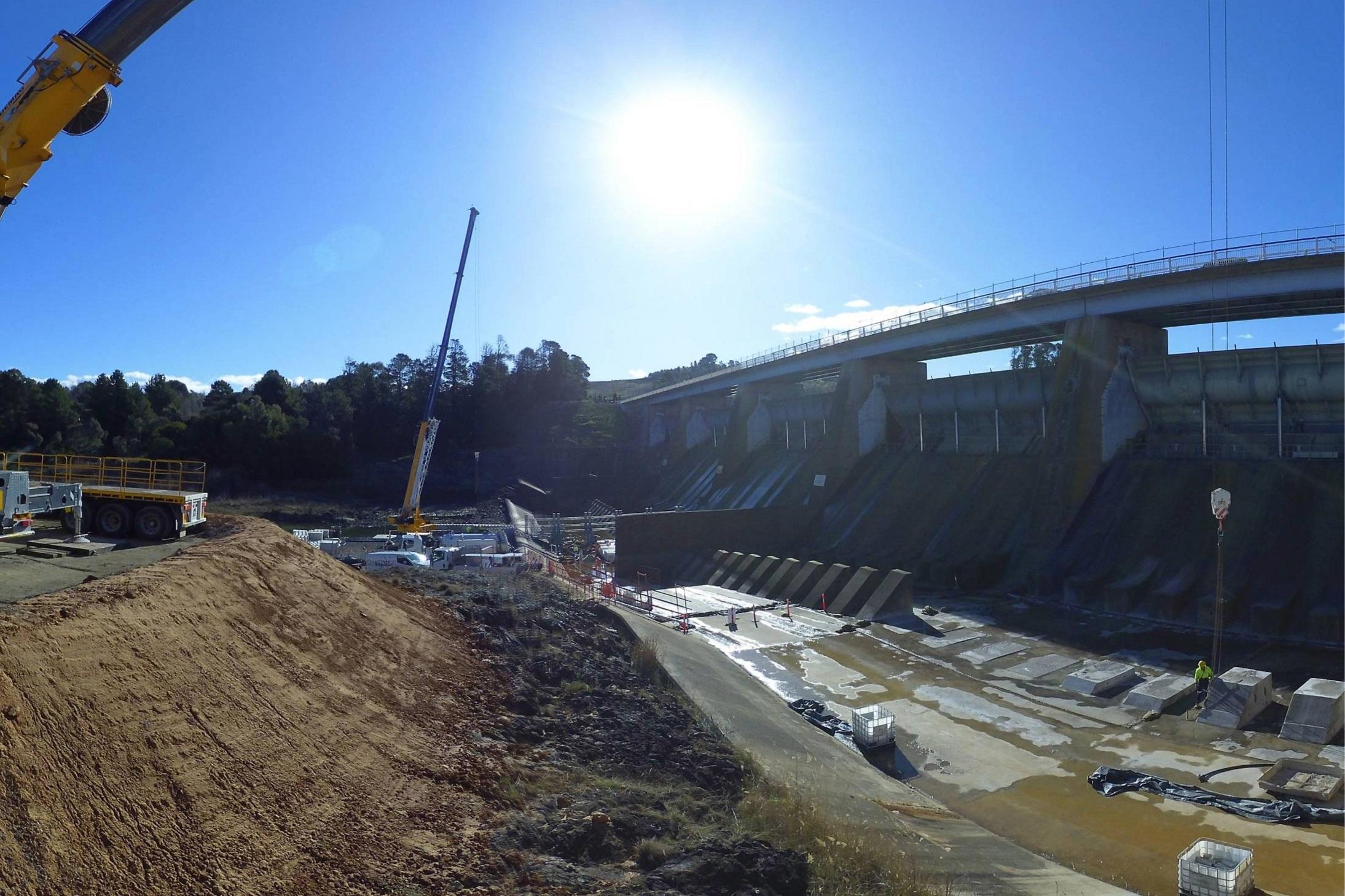 This image is from a timelapse camera showing the dam empty and two cranes on site with a number of baffle blocks removed.