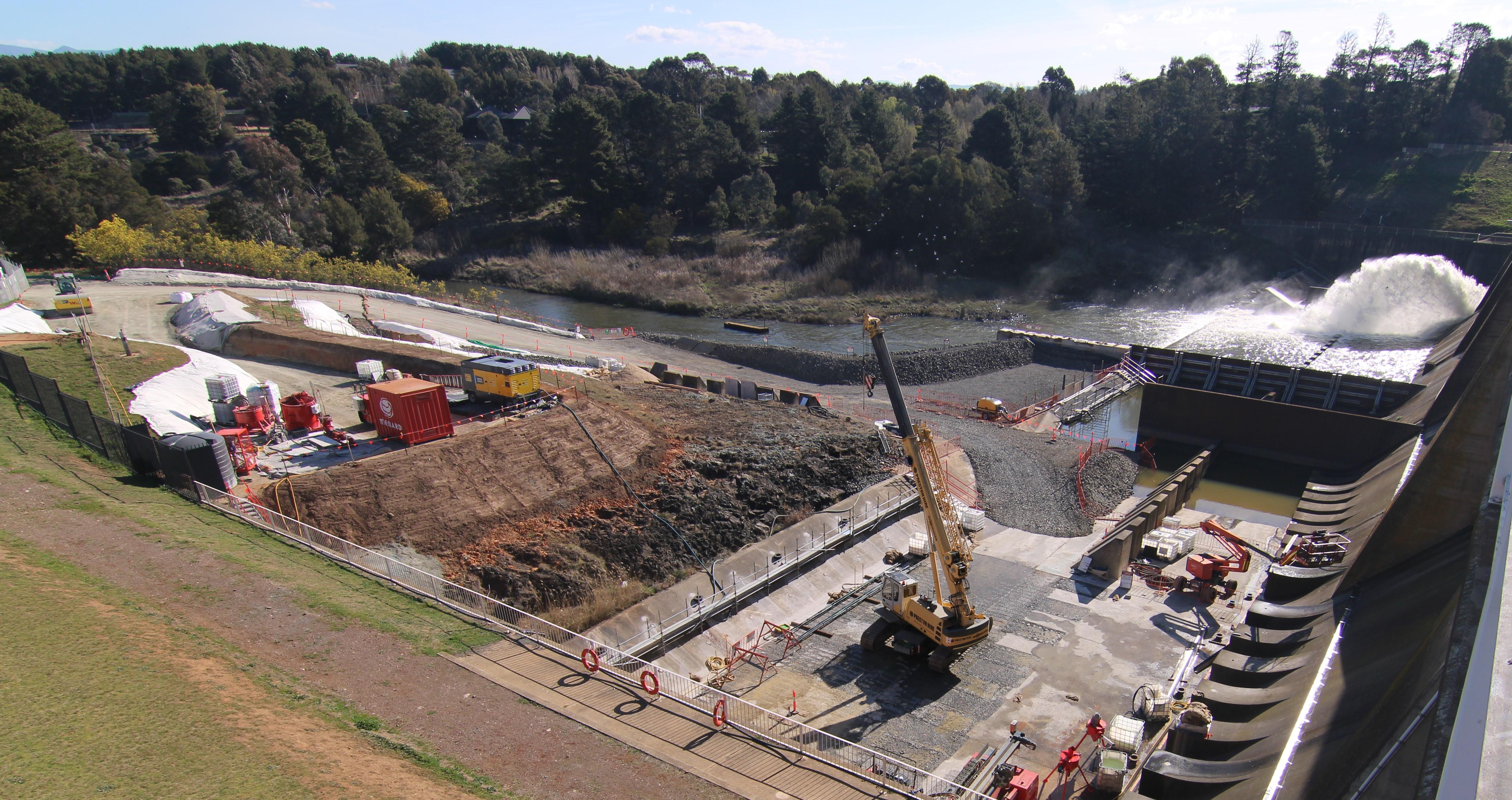 This image shows a water release occurring during the day with the cofferdam keeping the water out of the construction area.