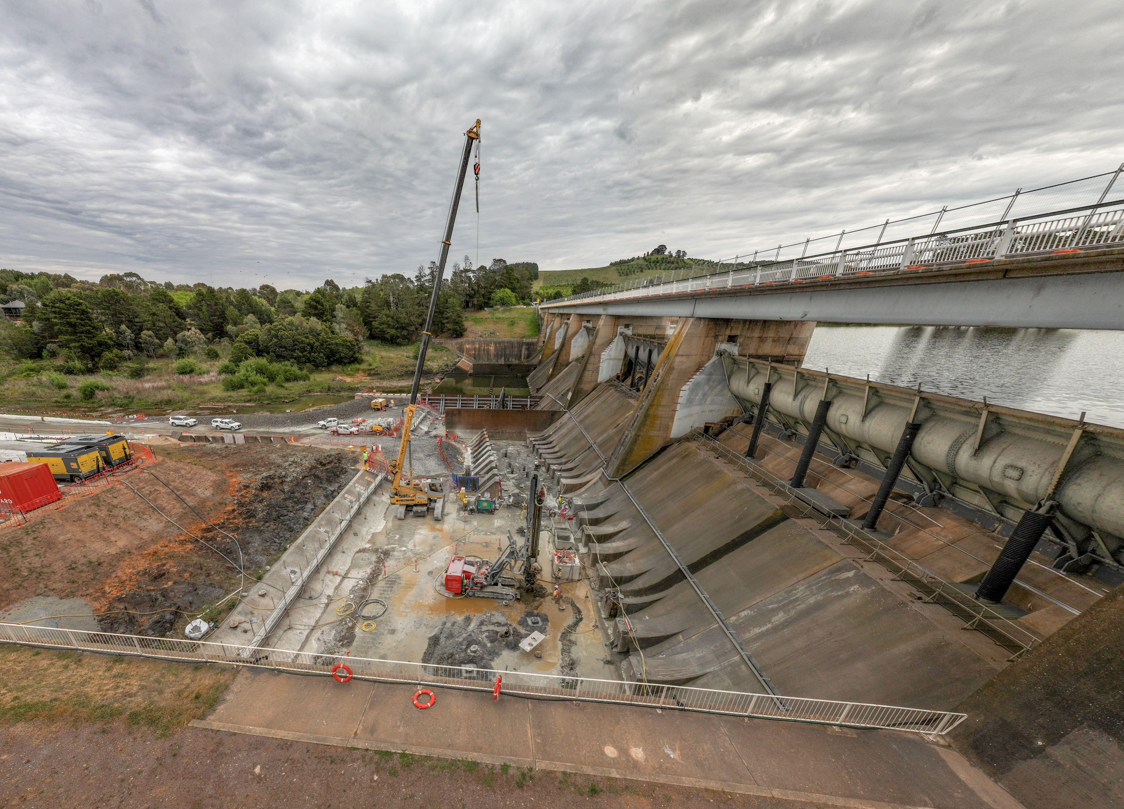 Wide lens shot showing construction underway at Scrivener Dam inclusive of crane movement