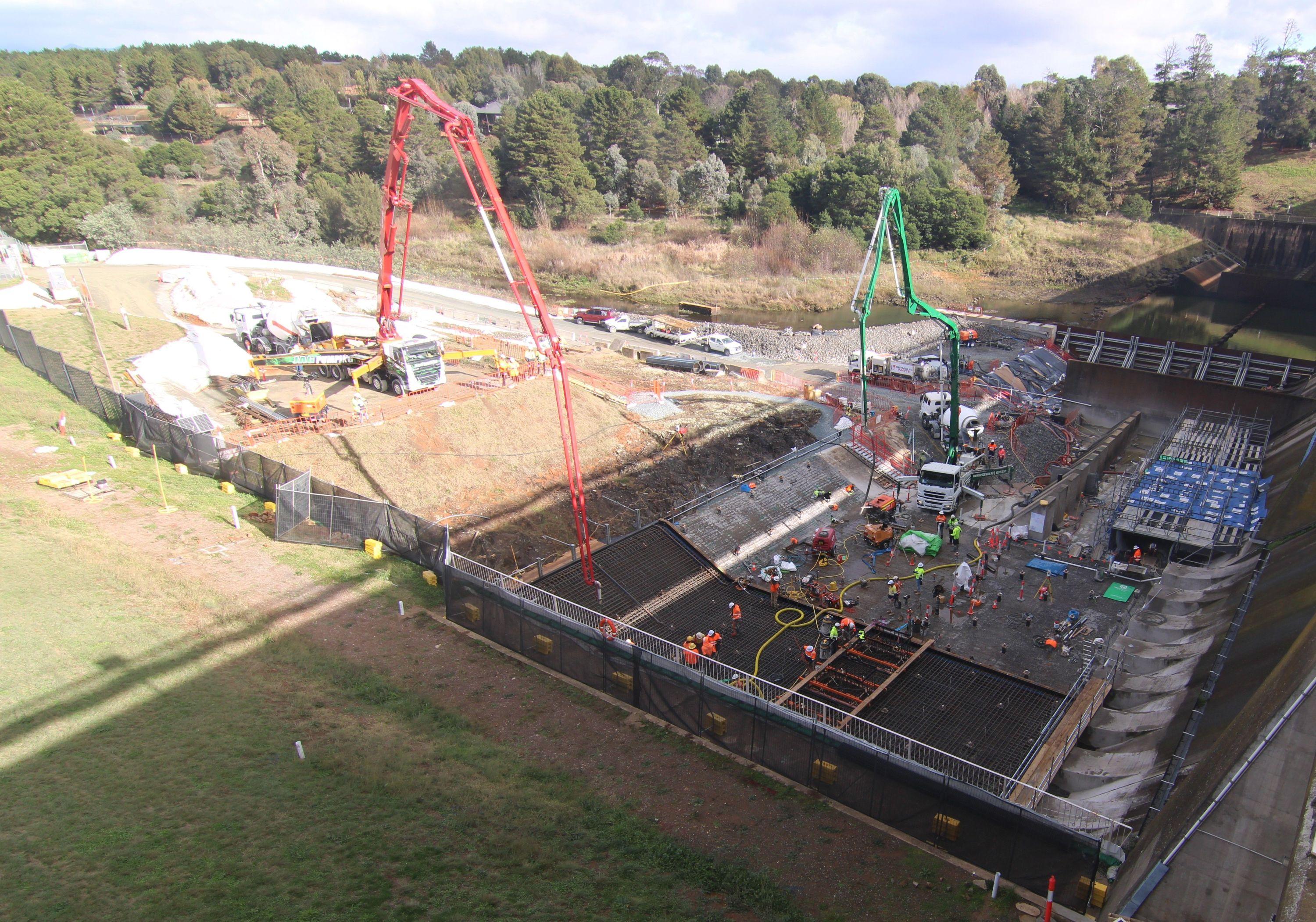 The image shows a major concrete pour underway with two concrete pumps operating.