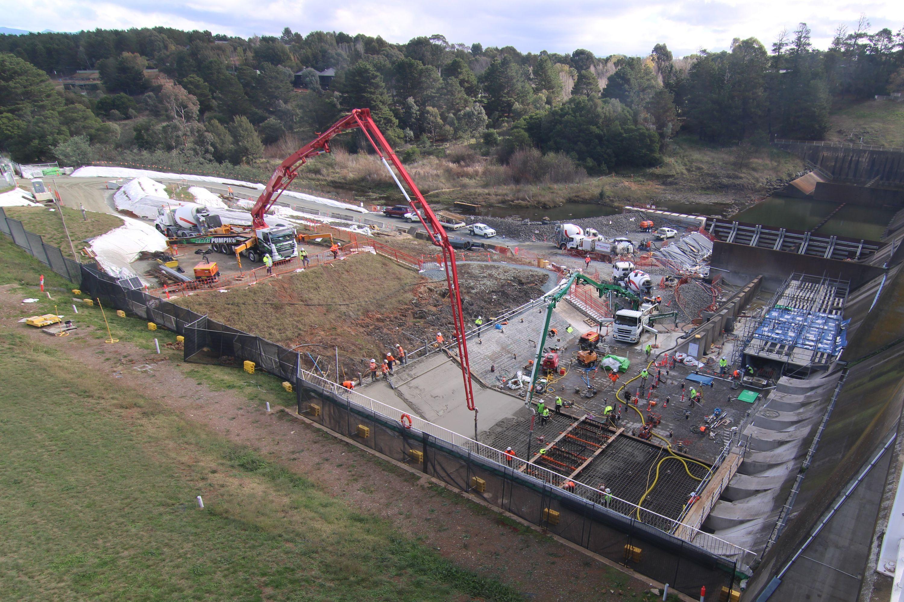 The image shows a major concrete pour underway with two concrete pumps operating.