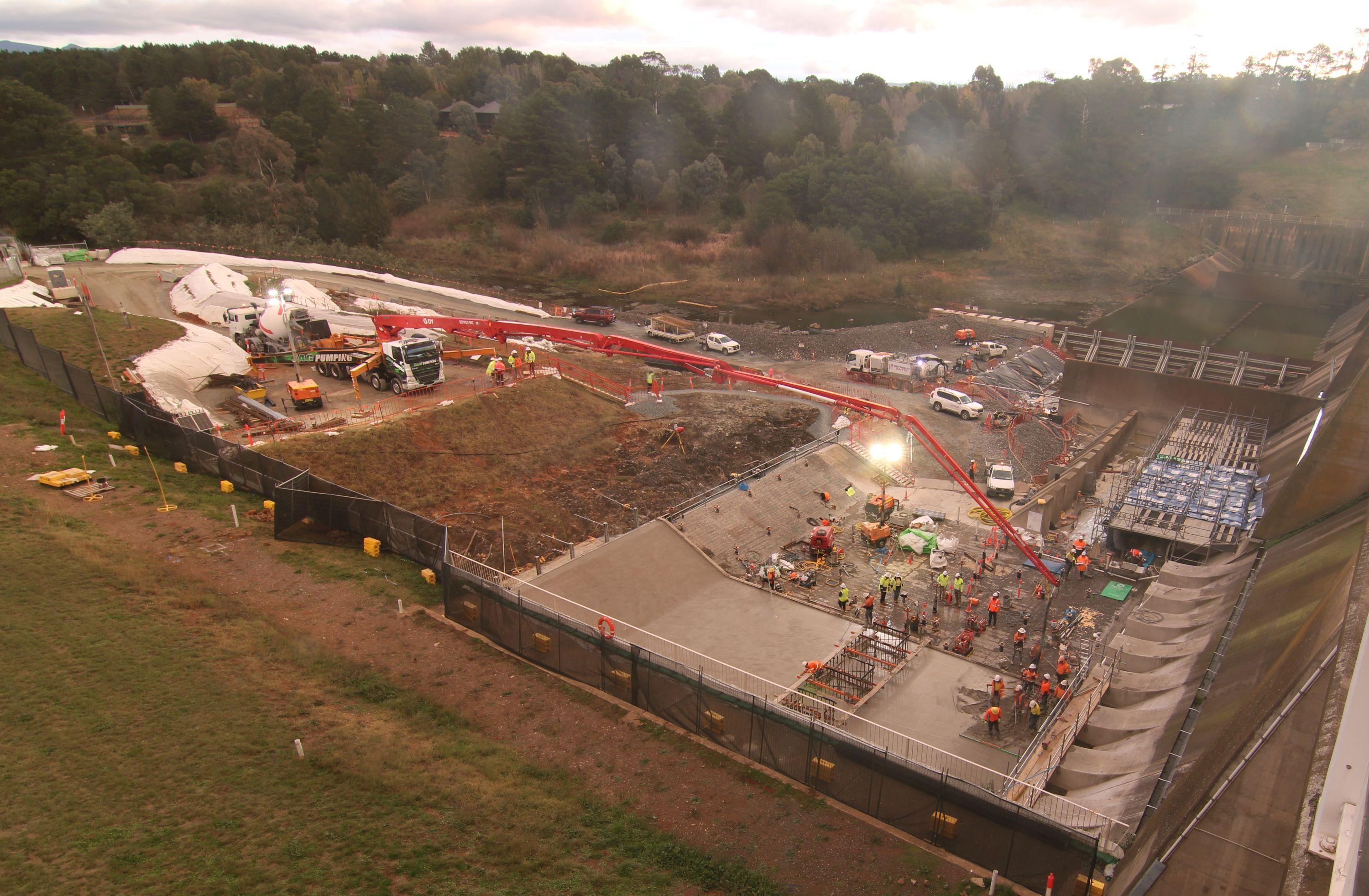 This image shows a major concrete pour underway as the sun begins sitting with most of the concrete slab now poured.