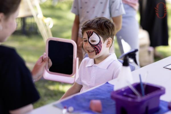 A child smiling wearing face paint.