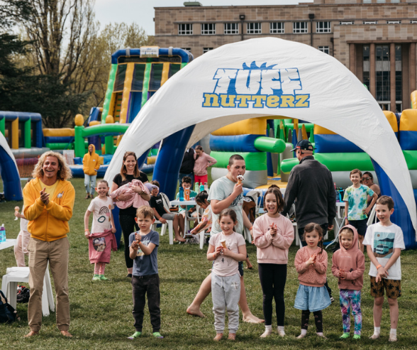 Adults and kids standing in front of a large inflatable course