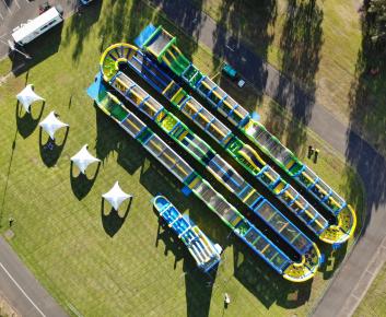 A large and colourful inflatable course on grass